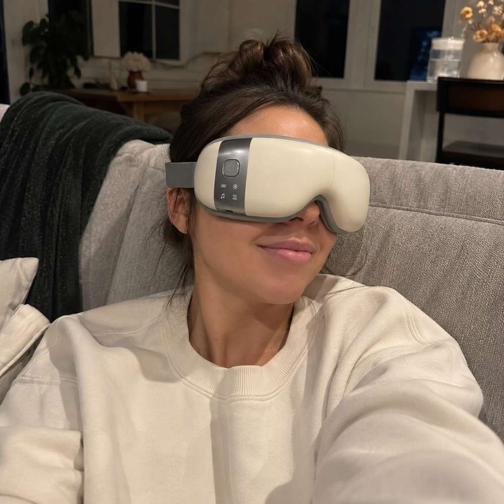 Woman wearing a white eye mask in a living room setting